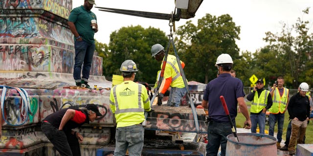 Crews move a section of the base as they attempt to locate a time capsule said to be buried in the base of the statue of on Monument Avenue in Richmond, Va., Thursday, Sept. 9, 2021.