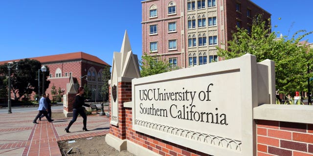  This March 12, 2019, file photo shows the University Village area of the University of Southern California, in Los Angeles. The first trial in the "Operation Varsity Blues" college admissions bribery scandal will begin this week, Wednesday, Sept. 8, 2021, with the potential to shed light on investigators' tactics and brighten the spotlight on a secretive school selection process many have long complained is rigged to favor the rich. (AP Photo/Reed Saxon, File)