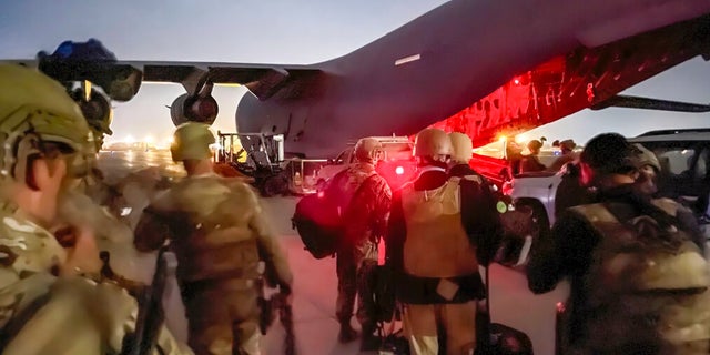 In this image provided by the U.S. Army, paratroopers assigned to the 82nd Airborne Division, and others, prepare to board a C-17 cargo plane at Hamid Karzai International Airport in Kabul, Afghanistan.