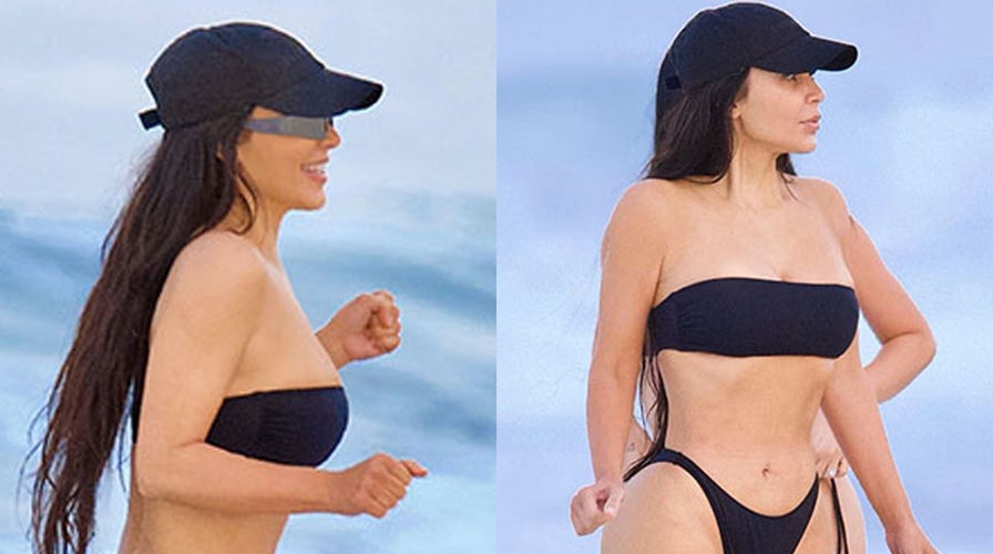 Kim Kardashian flaunts figure in cheeky black bikini during beach