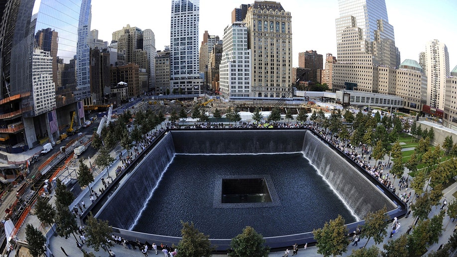 Families visit the 9/11 South Memorial Pool during 10th anniversary ceremonies at the World Trade Center site in New York, Sept. 11, 2011. 
