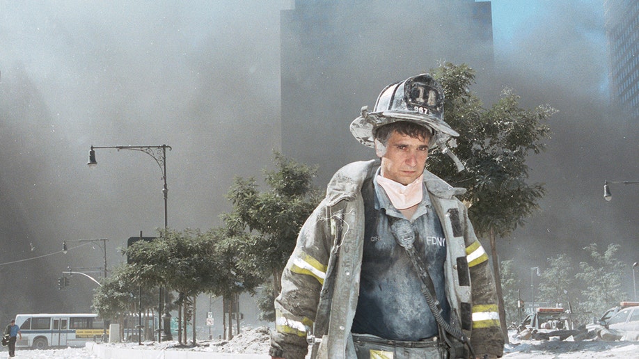 An unidentified New York City firefighter walks away from Ground Zero after the collapse of the Twin Towers Sept. 11, 2001, in New York City. 