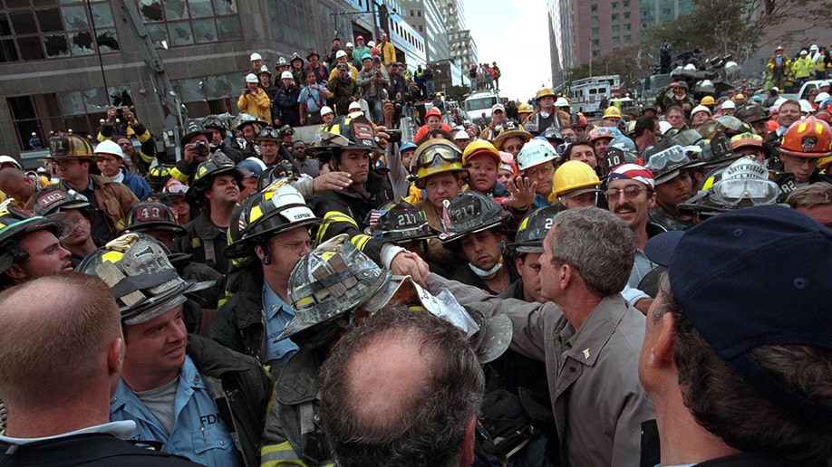 President George W. Bush greets firefighters, police, and rescue personnel while touring the site of the World Trade Center terrorist attack in New York City, New York, Sept. 14, 2001