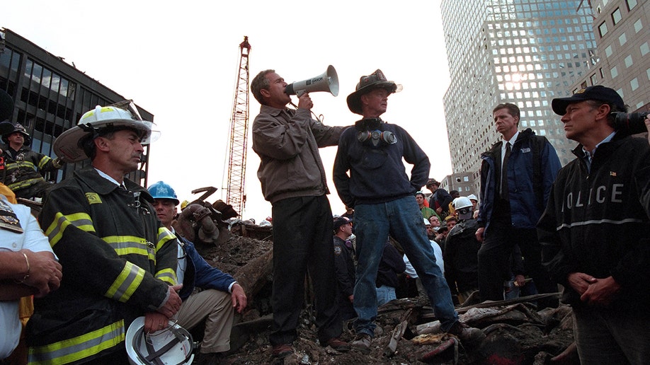 In wake of 9/11 attacks, President George W. Bush rallies firefighters and rescue workers during an impromptu speech at the site of the collapsed World Trade Center in New York City, New York, Sept. 14, 2001