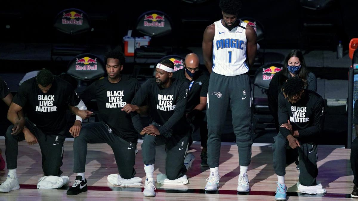 Orlando Magic's Jonathan Isaac stands as other players kneel before a game on July 31, 2020. (Ashley Landis / Pool Photo via USA TODAY Sports)
