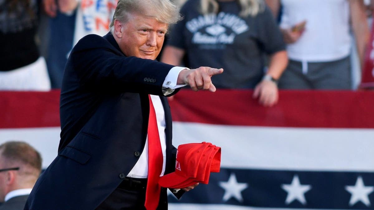 Former President Trump holds hats as he gestures during his first post-presidency campaign rally at the Lorain County Fairgrounds in Wellington, Ohio, June 26, 2021. (REUTERS/Gaelen Morse/File Photo)