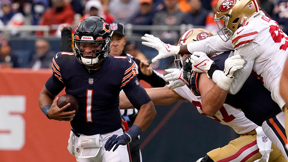 Chicago Bears quarterback Justin Fields (1) scrambles away from San Francisco 49ers' defenders Sunday, Oct. 31, 2021, in Chicago.