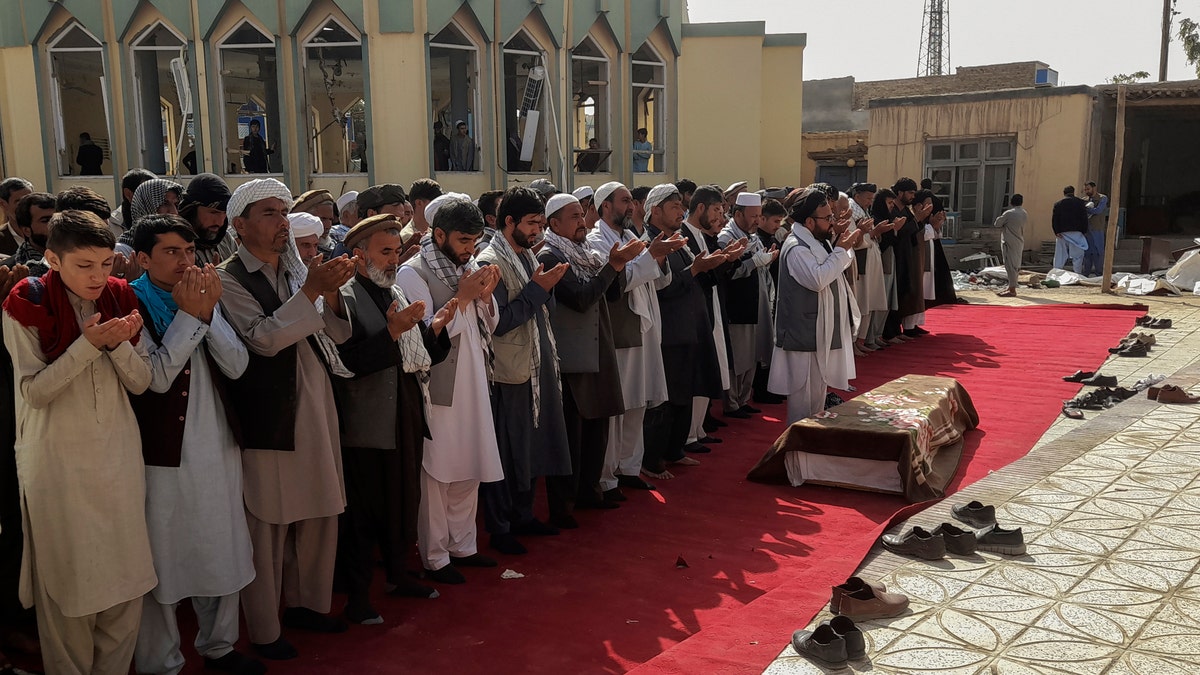 Relatives and residents pray during a funeral ceremony for victims of a suicide attack at the Gozar-e-Sayed Abad Mosque in Kunduz, northern Afghanistan, Saturday, Oct. 9, 2021. The mosque was packed with Shiite Muslim worshippers when an Islamic State suicide bomber attacked during Friday prayers, killing dozens in the latest security challenge to the Taliban as they transition from insurgency to governance. (AP Photo/Abdullah Sahil)