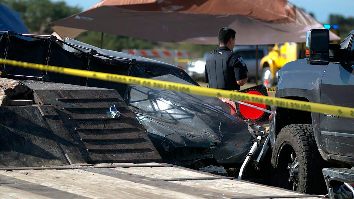 In this photo provided by Louis Amestoy, a police officer stands watch over the scene of a fatal drag racing crash at the Kerrville-Kerr County Airport in Kerrville, Texas, on Oct. 23, 2021.