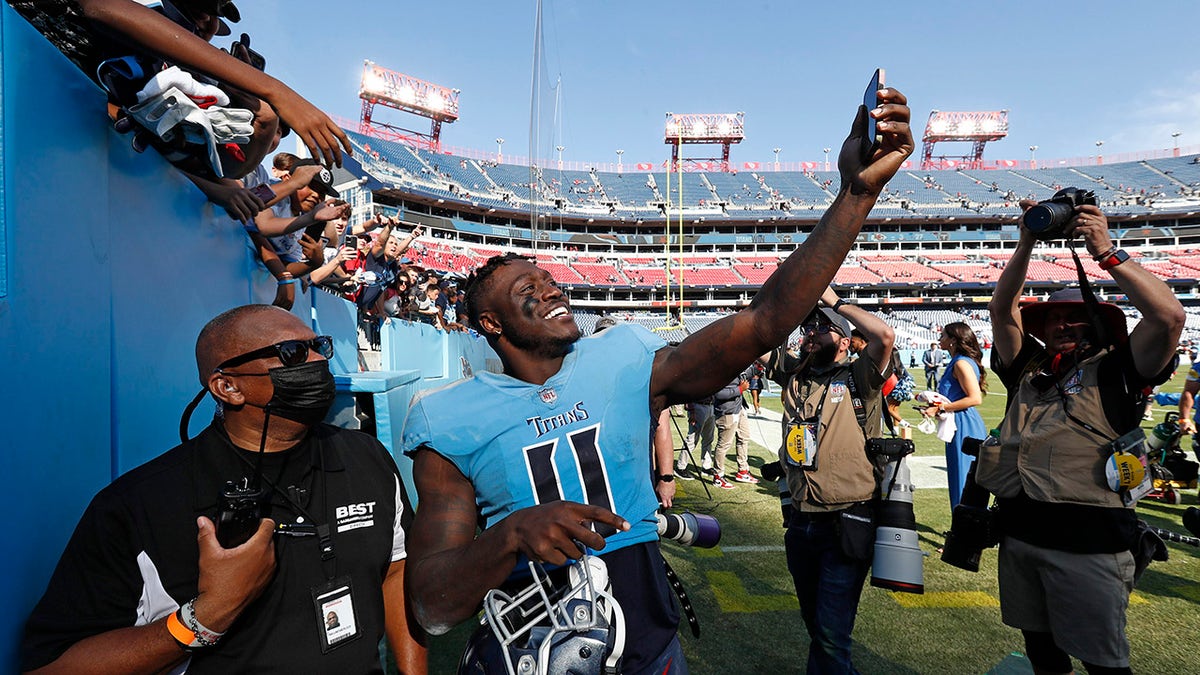 Tennessee Titans wide receiver A.J. Brown (11) takes a picture for a fan as he leaves the field after the Titans beat the Kansas City Chiefs 27-3 in an NFL football game Sunday, Oct. 24, 2021, in Nashville, Tenn.