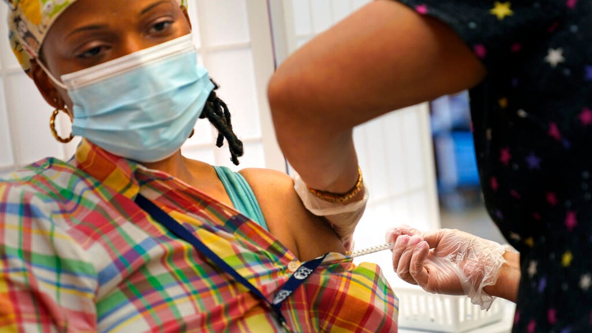 Shyrel Ritter, a certified nursing assistant at the Hebrew Home at Riverdale, receives her COVID-19 booster shot at her workplace in New York, Monday, Sept. 27, 2021.