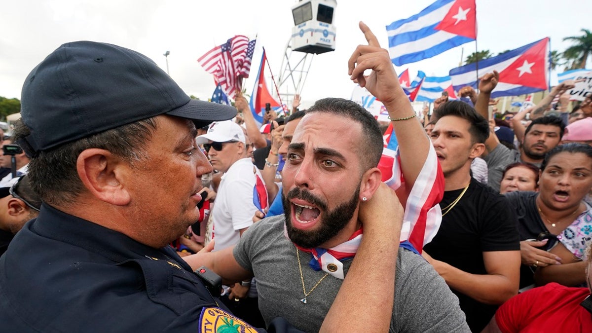 In this Wednesday, July 14, 2021, file photo, Miami Police Chief Art Acevedo, left, hugs a demonstrator, in Miami's Little Havana neighborhood, as people rallied in support of antigovernment demonstrations in Cuba. City of Miami commissioners held a special meeting last month in which they attacked Acevedo less than six months into his post, and voted to further investigate him and his appointment. (AP Photo/Wilfredo Lee, File)