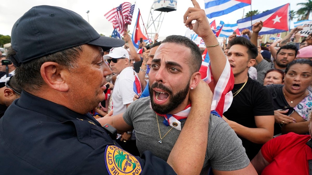 In this Wednesday, July 14, 2021, file photo, Miami Police Chief Art Acevedo, left, hugs a demonstrator, in Miami's Little Havana neighborhood, as people rallied in support of antigovernment demonstrations in Cuba. City of Miami commissioners held a special meeting last month in which they attacked Acevedo less than six months into his post, and voted to further investigate him and his appointment. (AP Photo/Wilfredo Lee, File)