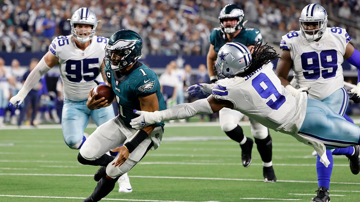 Philadelphia Eagles quarterback Jalen Hurts (1) runs the ball as Dallas Cowboys linebacker Jaylon Smith (9) attempts to make the stop in the second half of an NFL football game in Arlington, Texas, Monday, Sept. 27, 2021. (AP Photo/Michael Ainsworth)