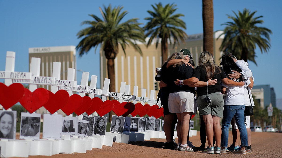 In this Oct. 1, 2019, file photo, people pray at a makeshift memorial for shooting victims in Las Vegas, on the anniversary of the mass shooting two years earlier. People who died, will be remembered Friday, Oct. 1, 2021, during the fourth anniversary of the Las Vegas massacre that became the deadliest mass shooting in modern U.S. history.
