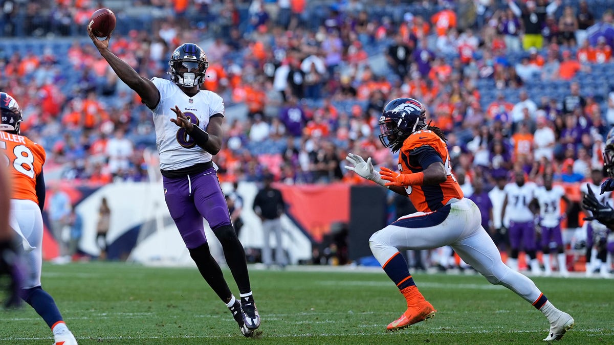 Baltimore Ravens quarterback Lamar Jackson (8) throws as Denver Broncos linebacker A.J. Johnson pursues during the second half of an NFL football game, Sunday, Oct. 3, 2021, in Denver.