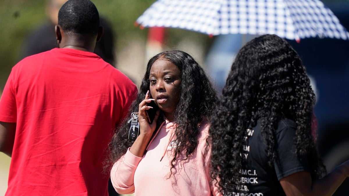 People gather on a road leading to Timberview High School after a shooting at the school in south Arlington, Texas on Wednesday. (AP Photo/LM Otero)