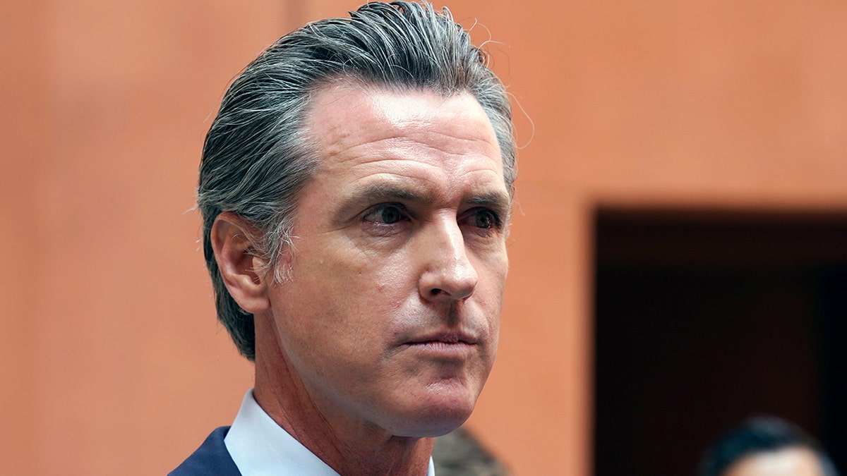 California Gov. Gavin Newsom listens to a question while meeting with reporters.