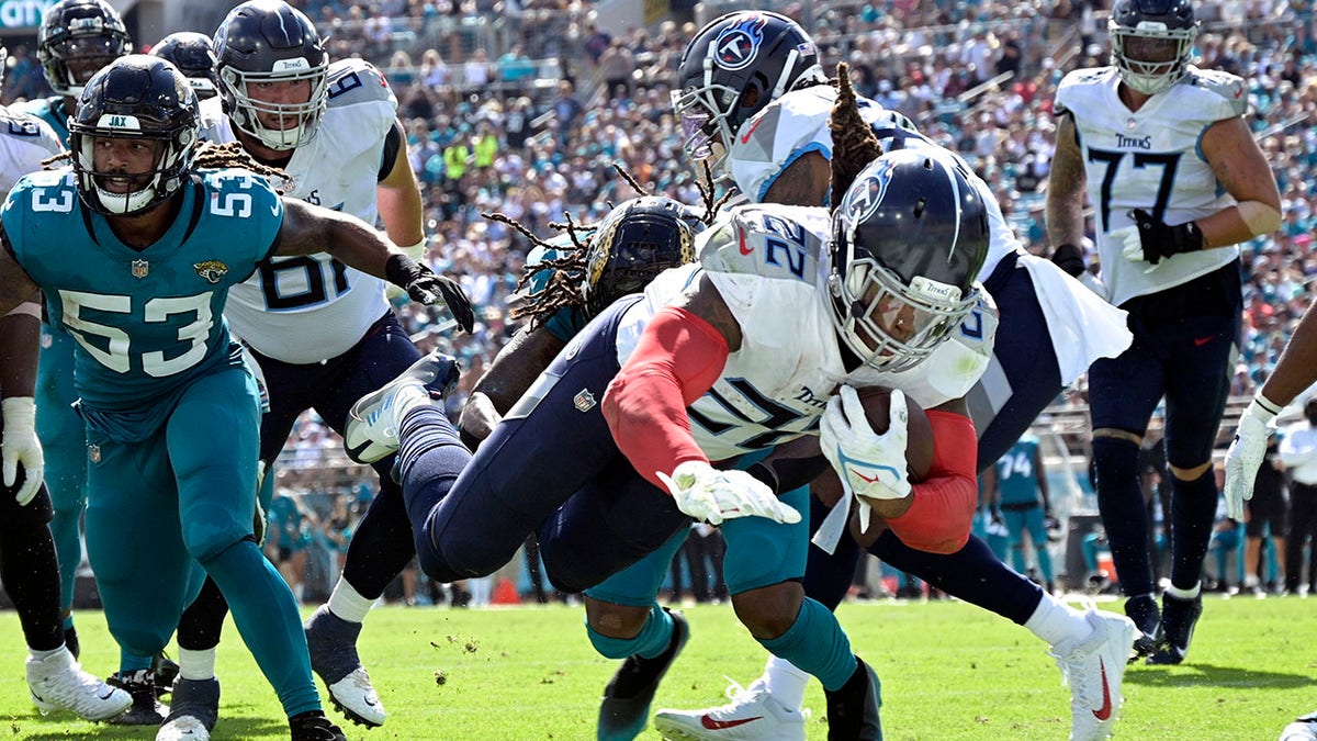 Tennessee Titans running back Derrick Henry (22) dives for a touchdown past Jacksonville Jaguars linebacker Dakota Allen (53) during the second half of an NFL football game, Sunday, Oct. 10, 2021, in Jacksonville, Fla. (AP Photo/Phelan M. Ebenhack)