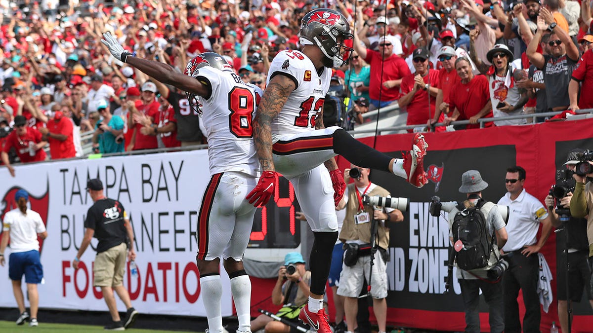 Tampa Bay Buccaneers wide receiver Mike Evans (13) celebrates his score against the Miami Dolphins with wide receiver Antonio Brown (81) during the second half of an NFL football game Sunday, Oct. 10, 2021, in Tampa, Fla.