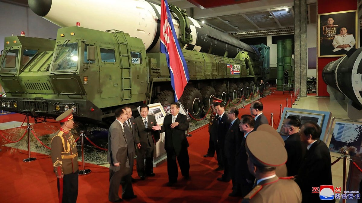 In this photo provided by the North Korean government, North Korean leader Kim Jong Un, center, speaks in front of what the North says is an intercontinental ballistic missile displayed at an exhibition of weapons systems in Pyongyang, North Korea, on Monday. 
