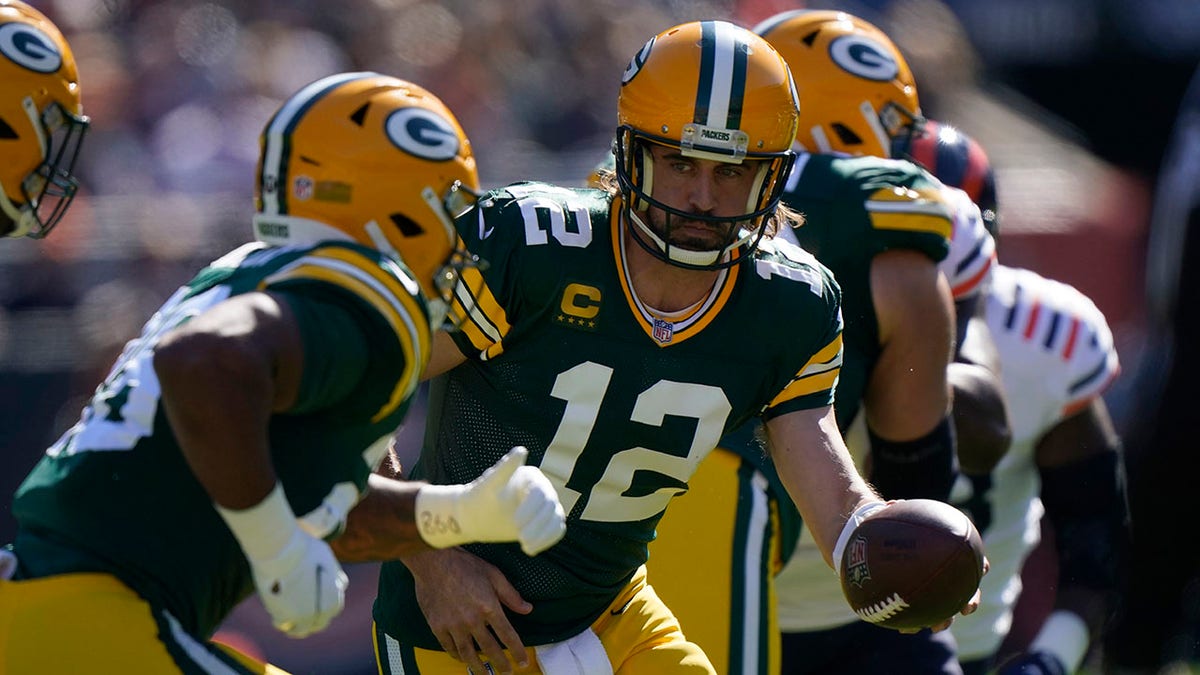 Green Bay Packers quarterback Aaron Rodgers (12) hands the ball off to running back A.J. Dillon during the first half of an NFL football game Sunday, Oct. 17, 2021, in Chicago.