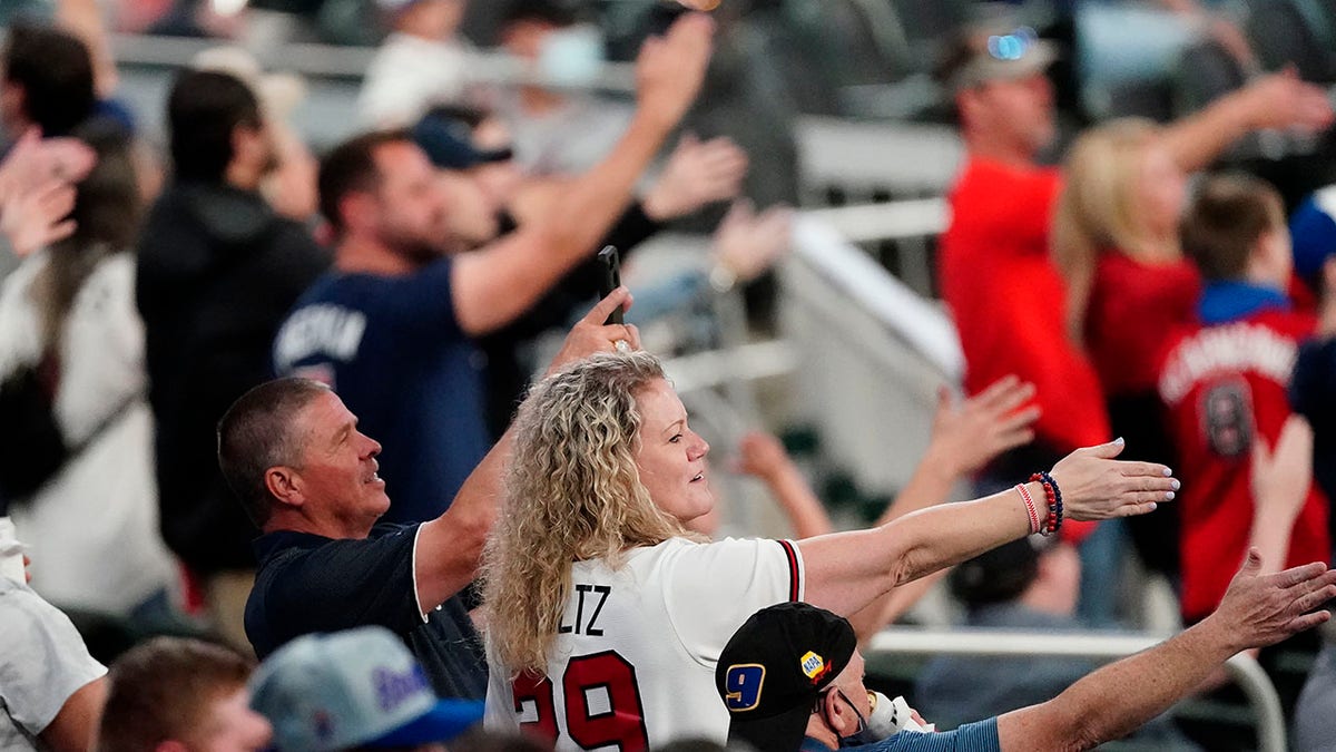 In this  April 2021 file photo, Atlanta Braves fans do the Tomahawk Chop during a game against the Philadelphia Phillies in Atlanta.