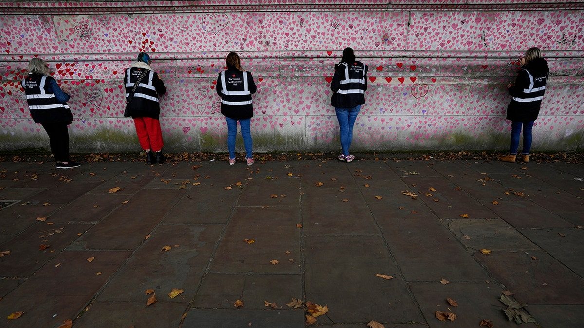 Volunteers work on the COVID-19 memorial wall in Westminster in London, Friday, Oct. 15, 2021. 