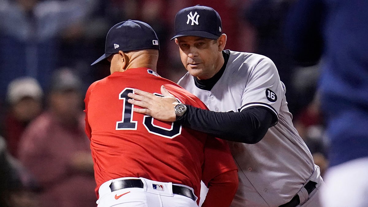 New York Yankees manager Aaron Boone, right, greets Boston Red Sox manager Alex Cora before an American League Wild Card baseball game at Fenway Park, Tuesday, Oct. 5, 2021, in Boston.