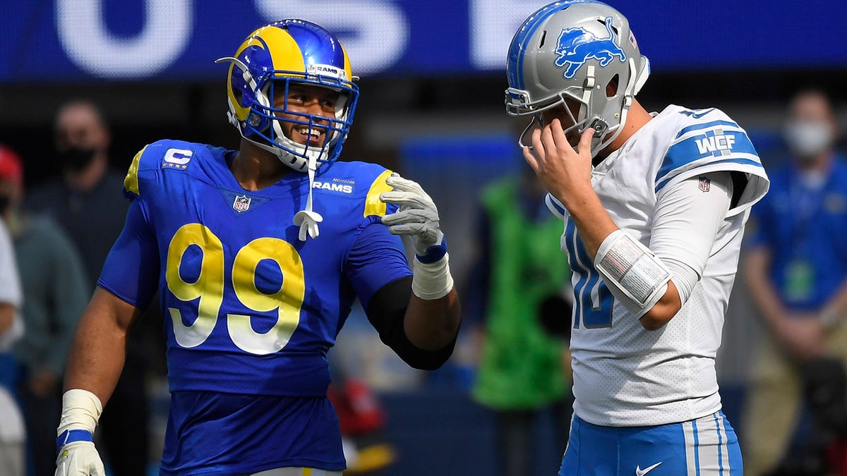 Detroit Lions quarterback Jared Goff, right, talks with Los Angeles Rams defensive end Aaron Donald during the first half of an NFL football game Sunday, Oct. 24, 2021, in Inglewood, California.