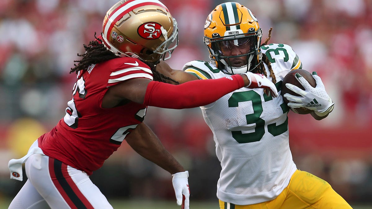 Green Bay Packers running back Aaron Jones (33) runs against San Francisco 49ers cornerback Josh Norman during the first half of an NFL football game in Santa Clara, Calif., Sunday, Sept. 26, 2021.
