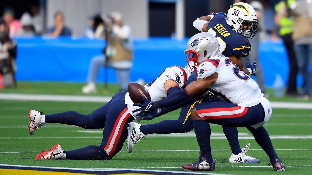 New England Patriots safety Adrian Phillips, right, intercepts a pass intended for Los Angeles Chargers running back Austin Ekeler (30) during the first half of an NFL football game Sunday, Oct. 31, 2021, in Inglewood, Calif.