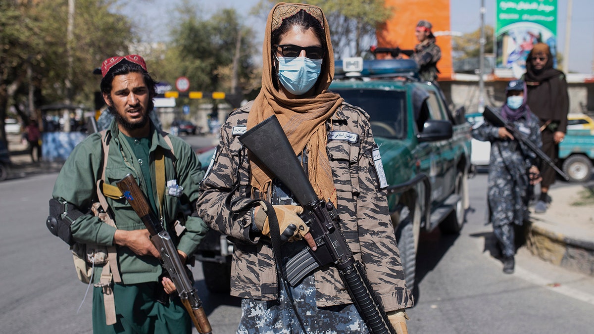 Taliban fighters stand guard during a women's protest in Kabul, Afghanistan, Thursday, Oct. 21, 2021. 