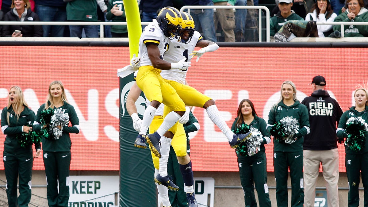 Michigan's Andrel Anthony, right, and A.J. Henning (3) celebrate Anthony's touchdown reception during the first quarter of a game against Michigan State, Saturday, Oct. 30, 2021, in East Lansing, Mich.