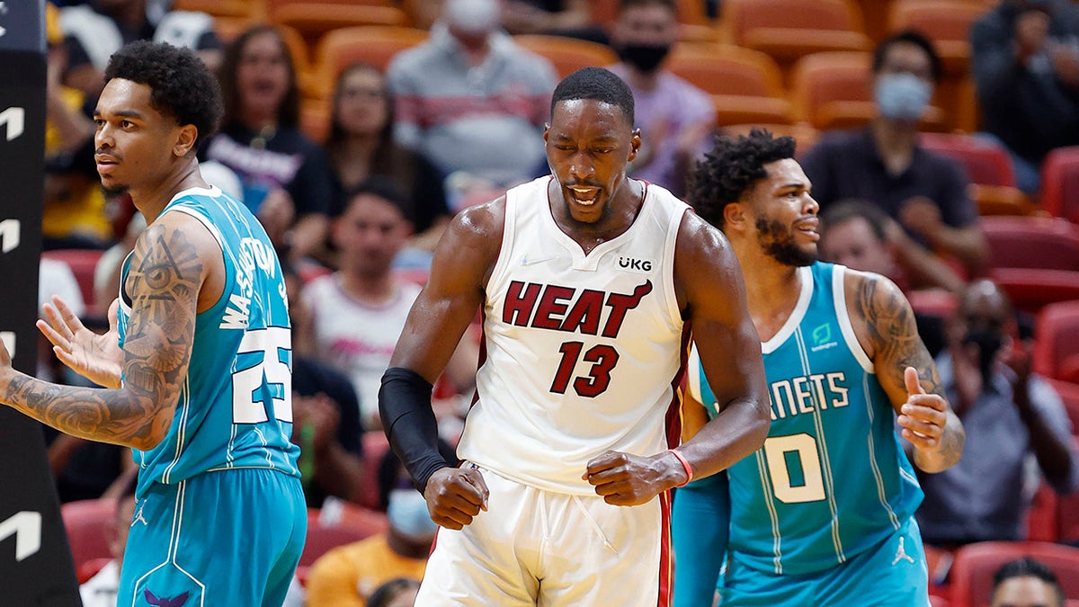 Miami Heat center Bam Adebayo (13) reacts after a play against Charlotte Hornets forward P.J. Washington (25) and forward Miles Bridges (0) during the first half Oct 11, 2021, at FTX Arena in Miami, Florida. 