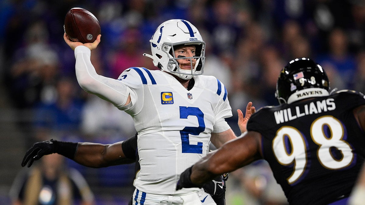 Indianapolis Colts quarterback Carson Wentz (2) throws the ball under pressure from Baltimore Ravens nose tackle Brandon Williams (98) during the first half of an NFL football game, Monday, Oct. 11, 2021, in Baltimore.