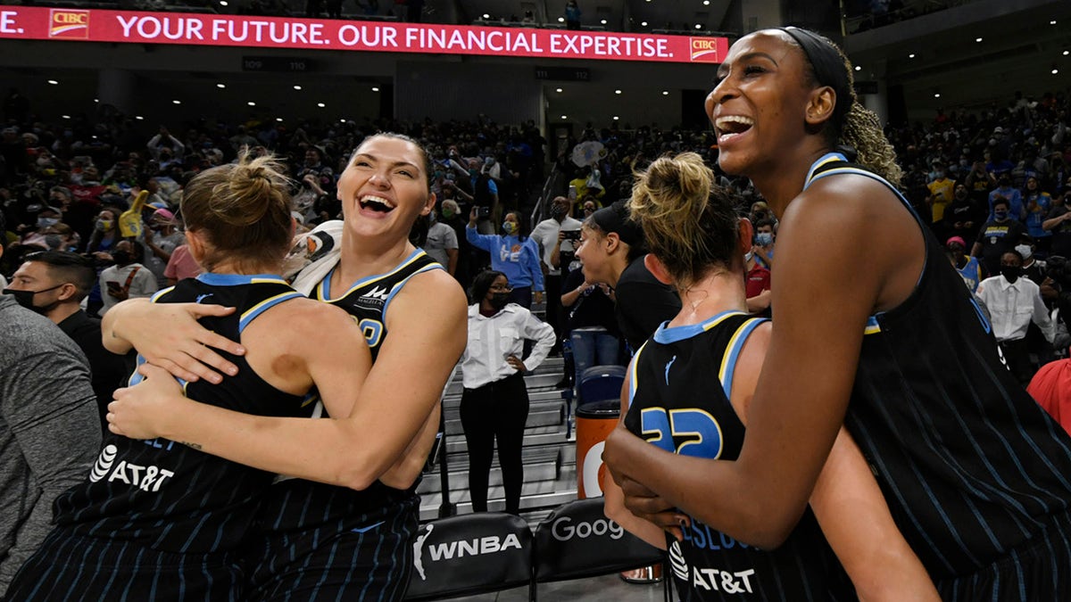 Chicago Sky's Astou Ndour-Fall, right, Courtney Vandersloot (22), Stefanie Dolson second from left, and Allie Quigley celebrate after the Sky defeated the Connecticut Sun 79-69 in Game 4 of a WNBA basketball semifinal series Wednesday, Oct. 6, 2021, in Chicago.