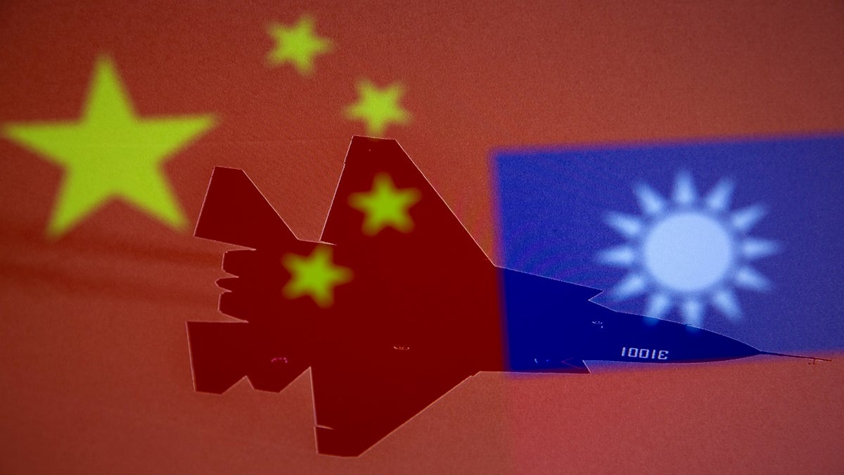 Chinese and Taiwanese national flags are displayed alongside a military airplane in this illustration taken April 9. (Reuters)