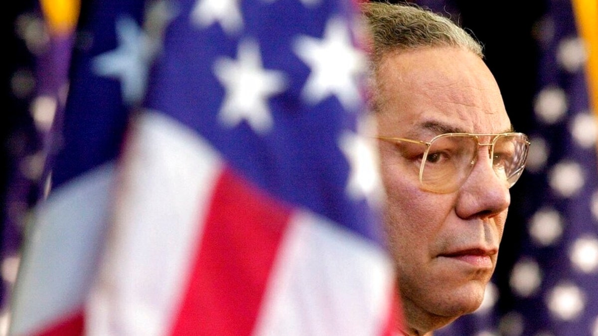 In this Feb. 15, 2001 file photo, Secretary of State Colin Powell looks on as President Bush addresses State Department employees at the State Department in Washington.