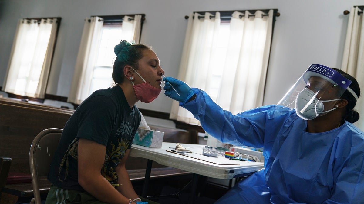 Jessica Leo, left, is tested for COVID-19 at a clinic set up at Bethel AME Church on Sept. 24, 2021, in Providence, Rhode Island.