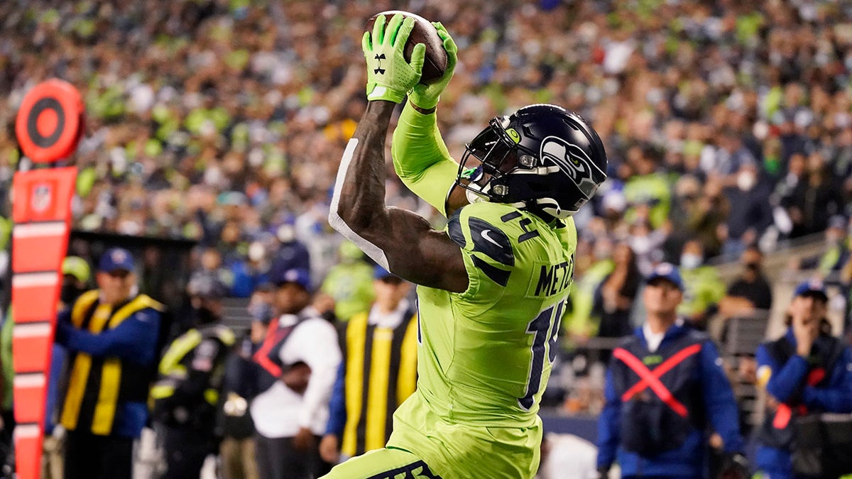 Seattle Seahawks wide receiver DK Metcalf catches a pass from backup quarterback Geno Smith for a touchdown against the Los Angeles Rams during the second half of an NFL football game, Thursday, Oct. 7, 2021, in Seattle.