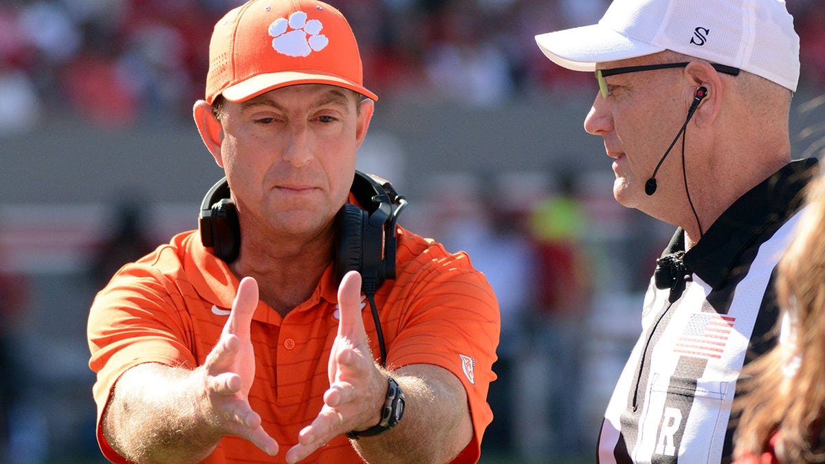 Clemson Tigers head coach Dabo Swinney (left) talks to an official during the first half against the North Carolina State Wolfpack at Carter-Finley Stadium.