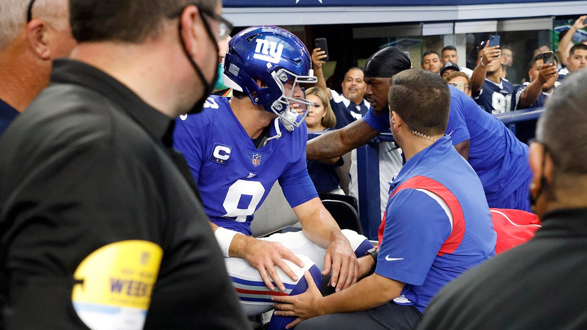 New York Giants' Daniel Jones (8) is carted off the field after suffering an unknown injury running the ball in the first half of a game against the Dallas Cowboys in Arlington, Texas, Sunday, Oct. 10, 2021.