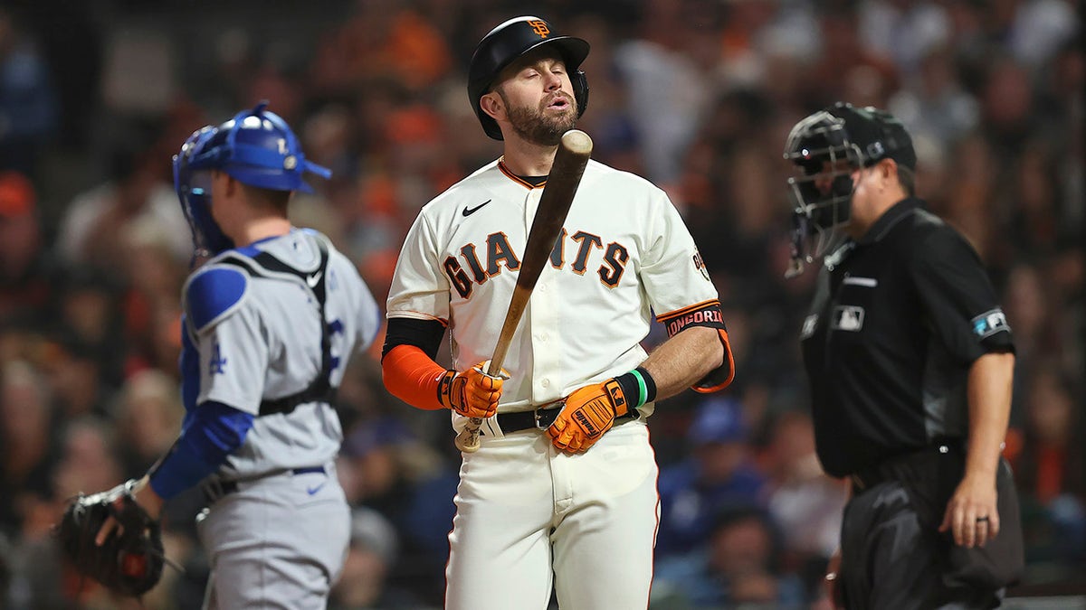 San Francisco Giants' Evan Longoria, middle, reacts after striking out against the Los Angeles Dodgers during the seventh inning of Game 5 of a baseball National League Division Series Thursday, Oct. 14, 2021, in San Francisco.