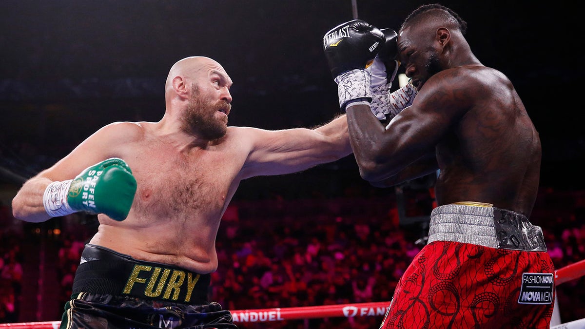 Tyson Fury, of England, hits Deontay Wilder in a heavyweight championship boxing match Saturday, Oct. 9, 2021, in Las Vegas. 