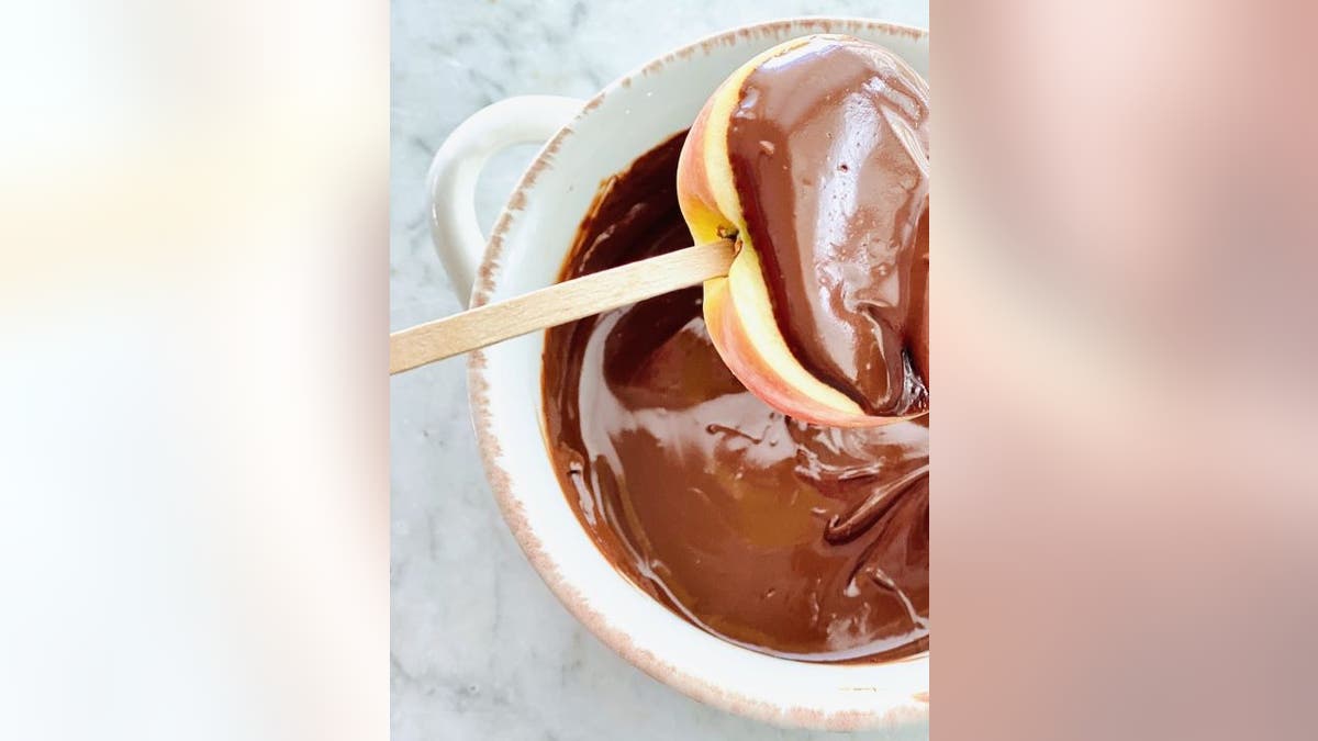 Each apple slice will need to get an ice cream stick inserted before being dipped into melted chocolate, according to Debi Morgan's ‘German Chocolate Caramel Apple’ recipe.