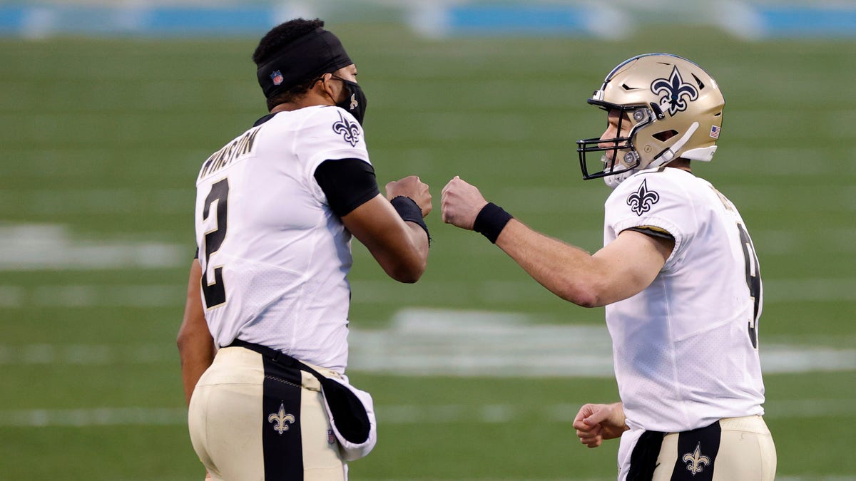 Drew Brees of the New Orleans Saints celebrates with teammate quarterback Jameis Winston following a touchdown pass against the Panthers on Jan. 3, 2021, in Charlotte, North Carolina.