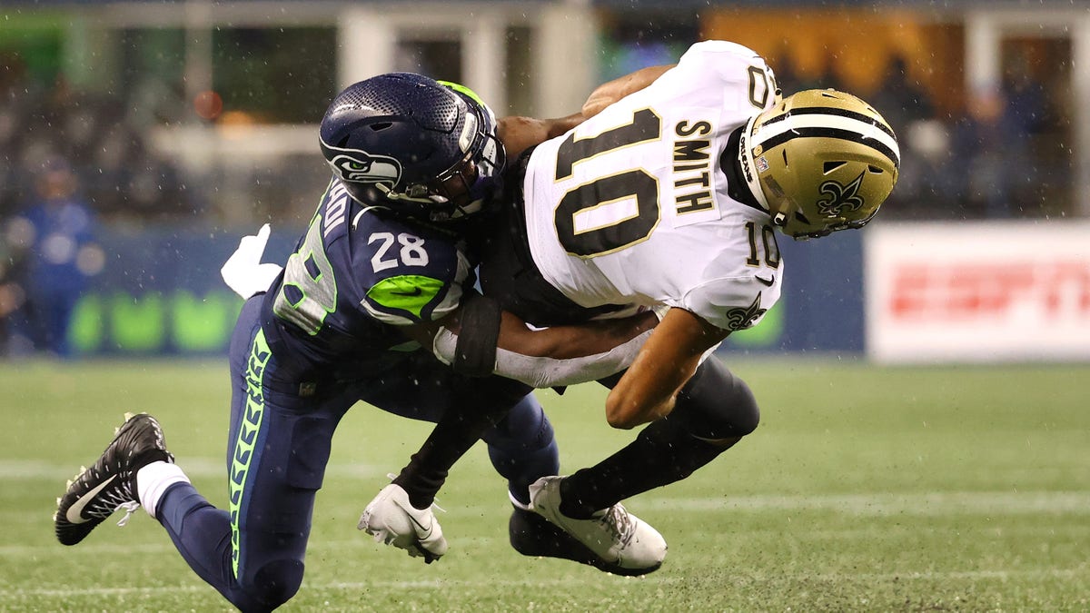 SEATTLE, WASHINGTON - OCTOBER 25: Tre'Quan Smith #10 of the New Orleans Saints is brought down by Ugo Amadi #28 of the Seattle Seahawks during the second half at Lumen Field on October 25, 2021 in Seattle, Washington.
