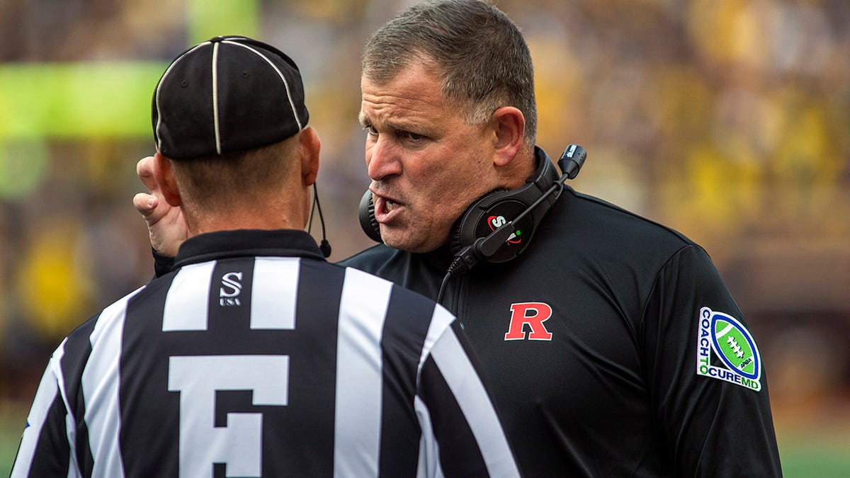 Rutgers head coach Greg Schiano speaks with a sideline official in the first quarter of an NCAA college football game against Michigan in Ann Arbor, Michigan, Saturday, Sept. 25, 2021.