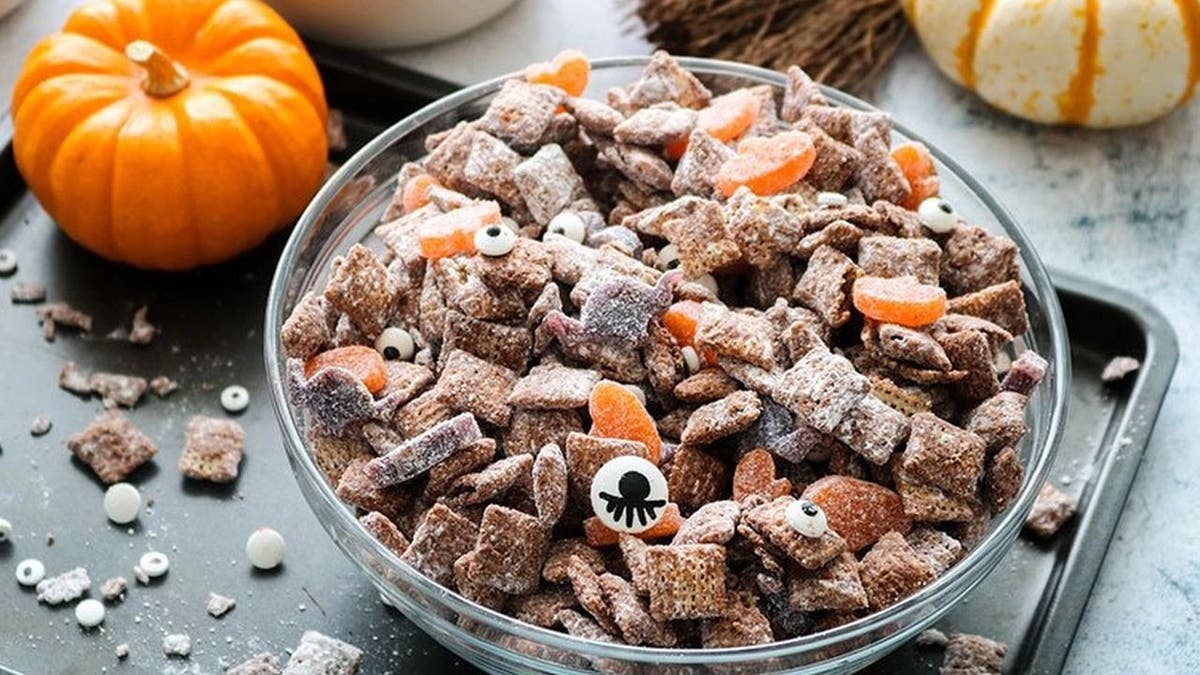 Gearing up for some Halloween treats? Whip up a batch of these festive muddy buddies — a medley of cereal with melted chocolate chips, peanut butter, Sour Punch candy, and more.